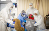 Magen David Adom medics and Shaare Zedek hospital team members wearing safety gear as they work in the coronavirus ward of Shaare Zedek hospital in Jerusalem on January 11, 2022.( Yonatan Sindel/Flash90)