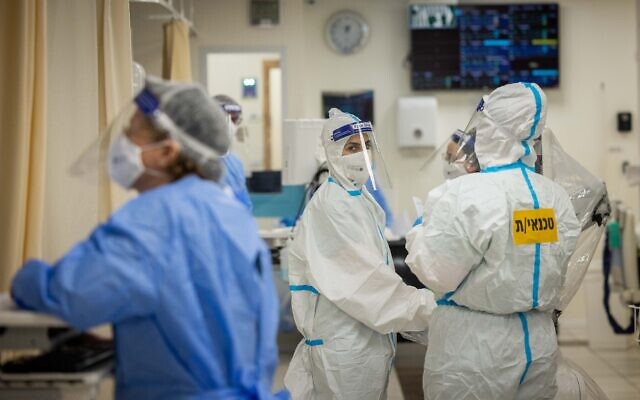 Hospital workers wear safety gear as they work in the coronavirus ward at Shaare Zedek Medical Center in Jerusalem, on January 11, 2022. (Yonatan Sindel/Flash90) Hospital workers wear safety gear as they work in the coronavirus ward at Shaare Zedek Medical Center in Jerusalem, on January 11, 2022. (Yonatan Sindel/Flash90)
