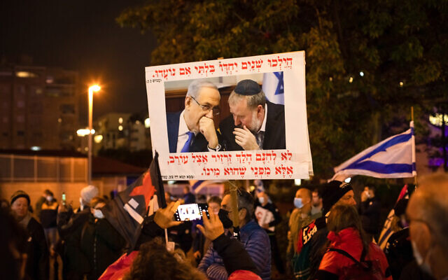 Demonstrators protest against a planned plea deal with Benjamin Netanyahu near the home of Attorney General Mandelblit, in Petah Tikva on January 15, 2022. (Chen Leopold/Flash90) Demonstrators protest against a planned plea deal with Benjamin Netanyahu near the home of Attorney General Mandelblit, in Petah Tikva on January 15, 2022. (Chen Leopold/Flash90)