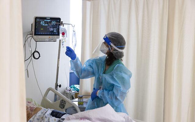 Shaare Zedek medical staff wear safety gear as they work in the coronavirus ward of the hospital in Jerusalem, on January 20, 2022. (Olivier Fitoussi/Flash90) Shaare Zedek medical staff wear safety gear as they work in the coronavirus ward of the hospital in Jerusalem, on January 20, 2022. (Olivier Fitoussi/Flash90)