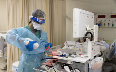 Shaare Zedek medical staff wear safety gear as they work in a coronavirus ward of the hospital in Jerusalem, January 20, 2022. (Olivier Fitoussi/Flash90) Shaare Zedek medical staff wear safety gear as they work in a coronavirus ward of the hospital in Jerusalem, January 20, 2022. (Olivier Fitoussi/Flash90)