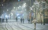 Snow falls on Jaffa street in Jerusalem, as a heavy storm hits nationwide, January 26, 2022. (Yonatan Sindel/Flash90)