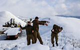 Israeli soldiers in the snow-covered Golan Heights, in northern Israel, after a heavy storm hit the nation, January 27, 2022. (Maor Kinsbursky/Flash90)