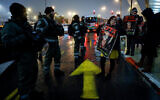 Nationalist activists protest the closure of a probe into the death of Ahuvia Sandak, at the entrance of Jerusalem, on January 27, 2022. (Olivier Fitoussi/Flash90)