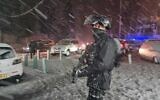 An Israeli policeman confronts rioters in East Jerusalem during a rare snow storm on January 26, 2022. (Israel Police)
