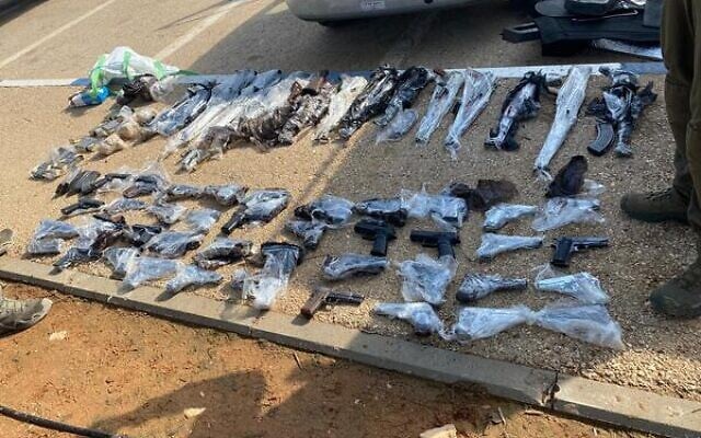 Dozens of guns recovered by Israeli soldiers and police that were allegedly smuggled into Israel from Jordan, on January 25, 2022. (Israel Defense Forces) Dozens of guns recovered by Israeli soldiers and police that were allegedly smuggled into Israel from Jordan, on January 25, 2022. (Israel Defense Forces)