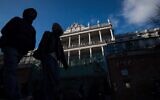 People walk past Palais Coburg, where closed-door nuclear talks take place in Vienna, Austria, December 17, 2021. (AP Photo/Michael Gruber)