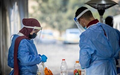 Health care workers take test samples in COVID-19 testing complex in Ma'ale Adumim, on December 30, 2021. (Yonatan Sindel/Flash90)