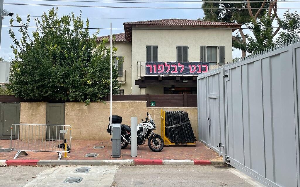 A Ra'anana home bifurcated by a security wall, with a "Bennett to Balfour" sign in Hebrew. January 13, 2022. (Carrie Keller-Lynn/Times of Israel) A Ra'anana home bifurcated by a security wall, with a "Bennett to Balfour" sign in Hebrew. January 13, 2022. (Carrie Keller-Lynn/Times of Israel)