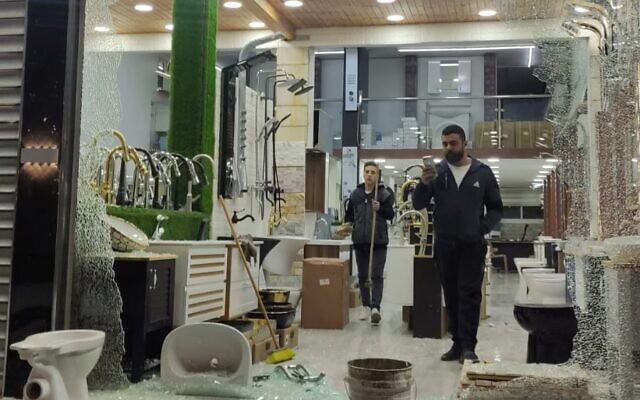 A Palestinian examines damage to a shop allegedly from Jewish extremist stone-throwing in Huwara, near Nablus, on Monday, January 24, 2022 (Courtesy)