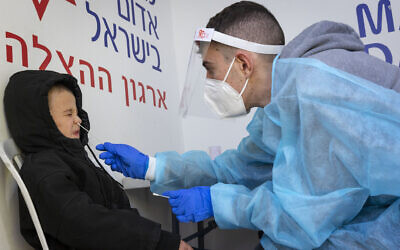 A health worker takes test samples of Israelis at a COVID testing center in Jerusalem on January 9, 2022. (Olivier Fitoussi/Flash90) A health worker takes test samples of Israelis at a COVID testing center in Jerusalem on January 9, 2022. (Olivier Fitoussi/Flash90)