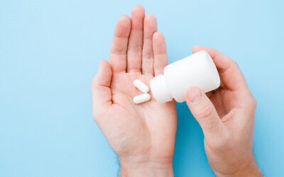 Illustrative: A man spills pills into his hand from a bottle (FotoDuets; iStock by Getty Images)