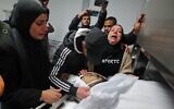 Family members mourn in a morgue in the Palestinian city of Ramallah in the West Bank on February 15, 2022, by the body of Nehad Bargouthi, a 19-year-old Palestinian who was allegedly shot by Israeli fire during a confrontation with Israeli troops in Nabi Saleh, northwest of Ramallah (Photo by JAAFAR ASHTIYEH / AFP)