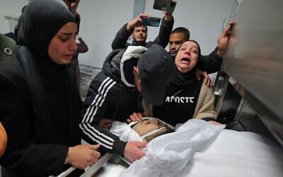 Family members mourn in a morgue in the Palestinian city of Ramallah in the West Bank on February 15, 2022, by the body of Nehad Bargouthi, a 19-year-old Palestinian who was allegedly shot by Israeli fire during a confrontation with Israeli troops in Nabi Saleh, northwest of Ramallah (Photo by JAAFAR ASHTIYEH / AFP)