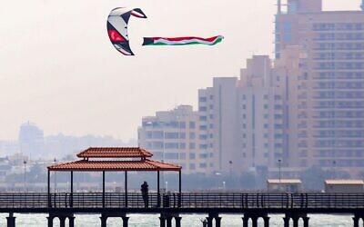 A paraglider flies the Kuwaiti national flag at a beach in Kuwait City, on February 19, 2022. (Yasser Al-Zayyat/AFP)