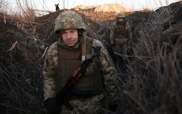 Ukrainian troops walk along trenches on the front line with Russia backed separatists, near Novognativka village, Donetsk region, on February 21, 2022. (Anatolii Stepanov/AFP) Ukrainian troops walk along trenches on the front line with Russia backed separatists, near Novognativka village, Donetsk region, on February 21, 2022. (Anatolii Stepanov/AFP)