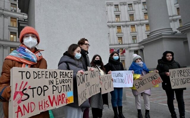 Protesters hold placards demanding sanctions during a rally outside the Ukrainian Ministry of Foreign Affair in Kyiv on February 21, 2022 (Sergei SUPINSKY / AFP) Protesters hold placards demanding sanctions during a rally outside the Ukrainian Ministry of Foreign Affair in Kyiv on February 21, 2022 (Sergei SUPINSKY / AFP)