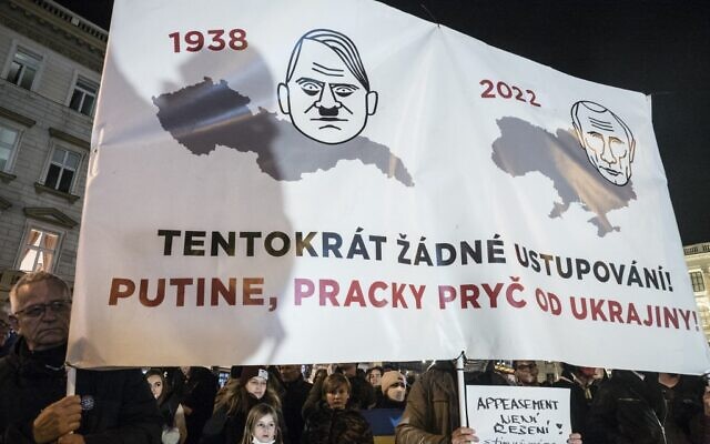 Pro-Ukraine demonstrators display a placard comparing Putin to Hitler during a demonstration in support to Ukraine at the Venceslas square in Prague, Czech Republic on February 22, 2022 (Michal Cizek / AFP) Pro-Ukraine demonstrators display a placard comparing Putin to Hitler during a demonstration in support to Ukraine at the Venceslas square in Prague, Czech Republic on February 22, 2022 (Michal Cizek / AFP)