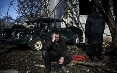 A man sits outside his destroyed building after bombings on the eastern Ukraine town of Chuguiv, on February 24, 2022. (Aris Messinis/AFP) A man sits outside his destroyed building after bombings on the eastern Ukraine town of Chuguiv, on February 24, 2022. (Aris Messinis/AFP)