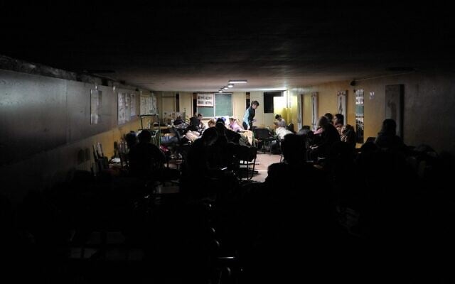 People hide in a bomb shelter in Kyiv in the early hours of February 25, 2022.(Sergei Chuzavkov/AFP)