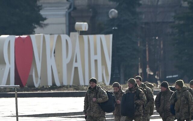 Ukrainian servicemen walk past a sign reading 'I love Ukraine' set at Independence Square in the Ukrainian capital of Kyiv, on February 25, 2022.  (Sergei Supinsky/AFP)