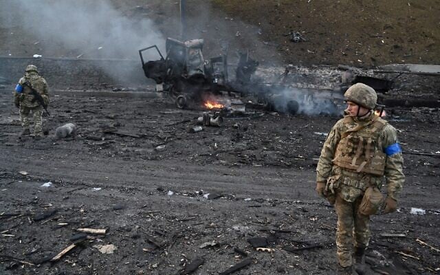 Ukrainian service members look for unexploded shells after fighting with a Russian raiding group in the Ukrainian capital of Kyiv in the morning of February 26, 2022, according to Ukrainian service personnel at the scene. (Sergei Supinsky/AFP)