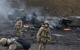 Ukrainian service members look for and collect unexploded shells after fighting with Russian troops in the Ukrainian capital of Kyiv in the morning of February 26, 2022. (Sergei Supinsky/AFP)