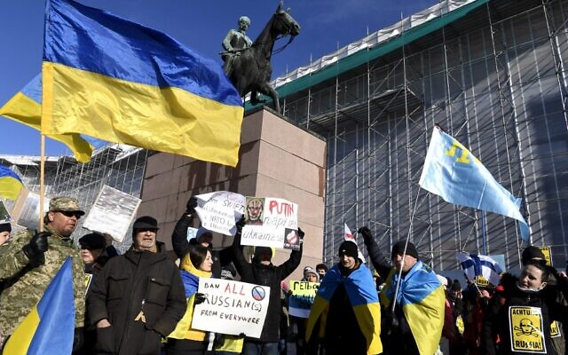 Demonstrators wave Ukrainian flags in order to show their support to Ukraine during a "We Stand with Ukraine" demonstration in Helsinki, Finland, on February 26, 2022. (Jussi Nukari / Lehtikuva / AFP)