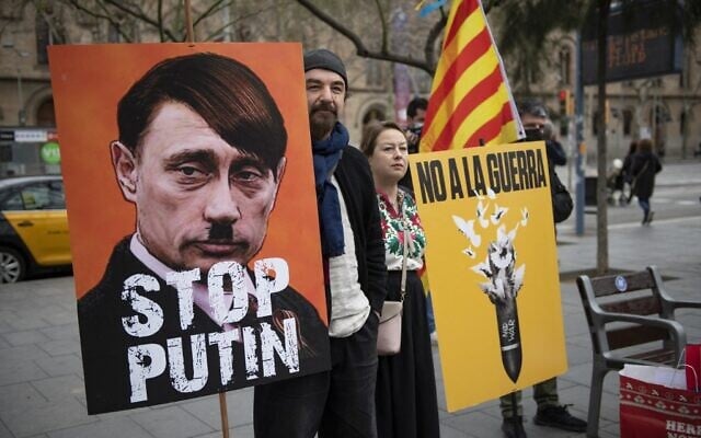 A demonstrator holds a sign depicting the Russian president as Adolf Hitler and reading 'Stop Putin' during a protest against Russia's military operation in Ukraine, in Barcelona on February 26, 2022. (Josep LAGO / AFP) A demonstrator holds a sign depicting the Russian president as Adolf Hitler and reading 'Stop Putin' during a protest against Russia's military operation in Ukraine, in Barcelona on February 26, 2022. (Josep LAGO / AFP)