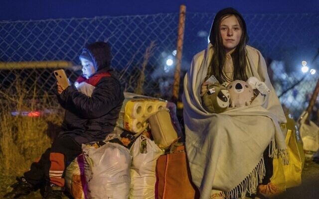 Helena (R) and her brother Bodia (L) from Lviv are seen at the Medyka pedestrian border crossing, in eastern Poland on February 26, 2022, following the Russian invasion of Ukraine (Wojtek RADWANSKI / AFP)
