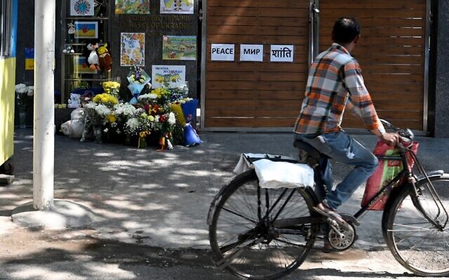 A cyclist peddles past the main gate of the Ukrainian embassy where flowers, soft toys and posters are placed as a sign of support in New Delhi on February 27, 2022. (Money SHARMA / AFP) A cyclist peddles past the main gate of the Ukrainian embassy where flowers, soft toys and posters are placed as a sign of support in New Delhi on February 27, 2022. (Money SHARMA / AFP)