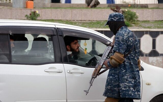 A Taliban fighter checks a vehicle along a road in Kandahar, Afghanistan, on February 28, 2022. (Javed Tanveer/AFP) A Taliban fighter checks a vehicle along a road in Kandahar, Afghanistan, on February 28, 2022. (Javed Tanveer/AFP)