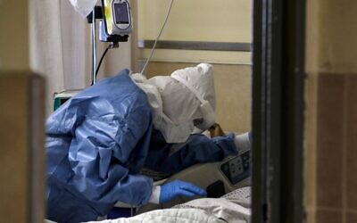 A medical worker tends to a patient infected by the coronavirus, in an isolation ward at the Ziv Medical Centre in Safed, on February 6, 2022 (JALAA MAREY / AFP)