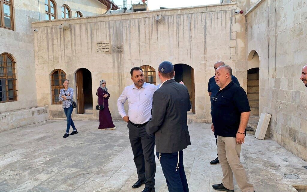 Rabbi Mendy Chitrik, wearing kippah, speaks with locals at the newly-renovated synagogue in Kilis, Turkey, August 21, 2021. (Mendy Chitrik/ via JTA)