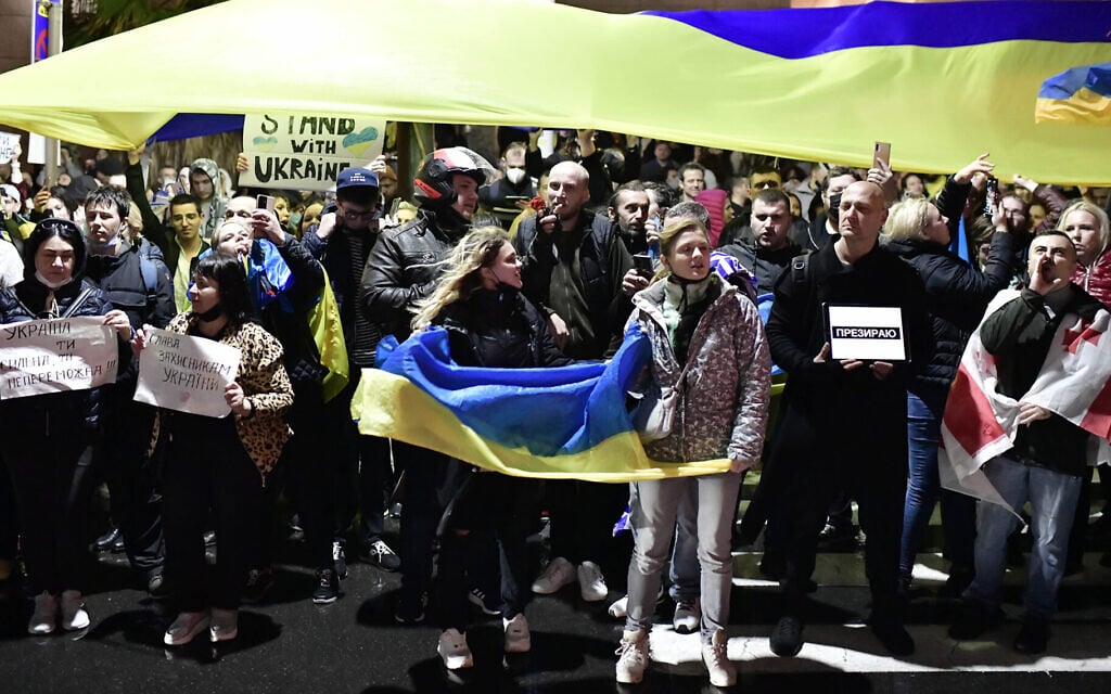 Demonstrators carry placards and flags during a protest outside the Russian Embassy in Tel Aviv, Feb. 24, 2022. (Tomer Neuberg/Flash90)