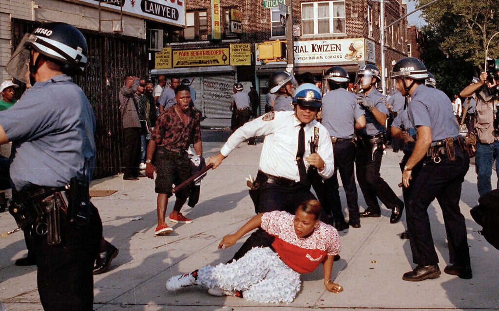In this August 21, 1991 file photo, New York City Police Department officers scuffle with a protester during a march through the Crown Heights section of the Brooklyn borough of New York. (AP Photo/Joe Major, File)