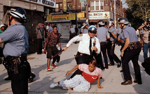 In this August 21, 1991 file photo, New York City Police Department officers scuffle with a protester during a march through the Crown Heights section of the Brooklyn borough of New York. (AP Photo/Joe Major, File)
