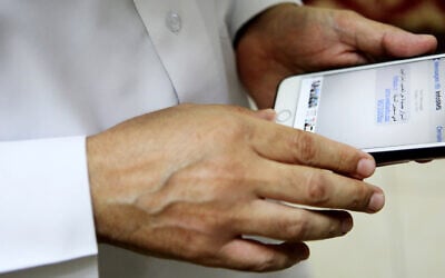Illustrative: Human rights activist Ahmed Mansoor shows Associated Press journalists a screenshot of a spoof text message, used to attempt to hack him, in Ajman, United Arab Emirates, August 25, 2016. (AP Photo/Jon Gambrell)