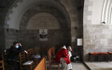 Priests pause on Palm Sunday on the Mount of Olives in Jerusalem, on Sunday, March 28, 2021. (AP Photo/Mahmoud Illean)