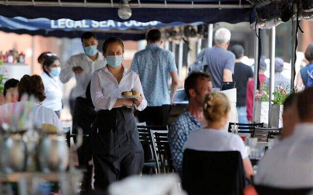 A server carries rolls to a table of customers seated outside at Legal Sea Foods, on May 26, 2021, in Boston. (AP Photo/Mary Schwalm) A server carries rolls to a table of customers seated outside at Legal Sea Foods, on May 26, 2021, in Boston. (AP Photo/Mary Schwalm)
