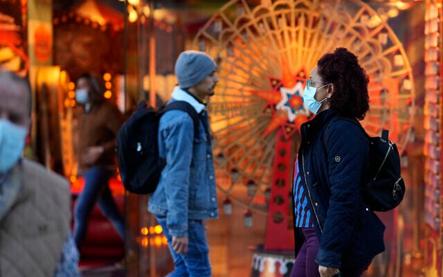 People wearing face masks walk in downtown Lisbon, Portugal, December 6, 2021. (AP Photo/Armando Franca) People wearing face masks walk in downtown Lisbon, Portugal, December 6, 2021. (AP Photo/Armando Franca)