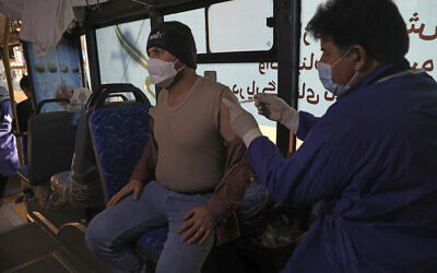 A man receives a COVID-19 vaccine at a mobile vaccine clinic bus at the Grand Bazaar of Tehran, Iran, Saturday, Jan. 22, 2022. (AP/Vahid Salemi)