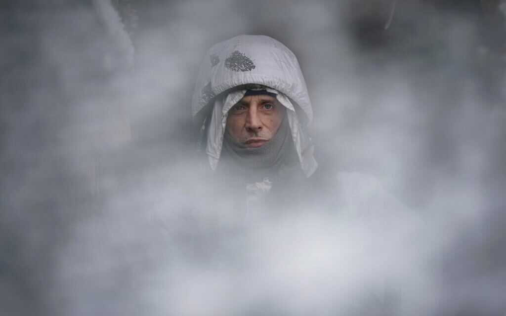 A Ukrainian serviceman, seen through a camouflage mesh, stands at a frontline position in the Luhansk region, eastern Ukraine, Saturday, Jan. 29, 2022. (AP Photo/Vadim Ghirda) A Ukrainian serviceman, seen through a camouflage mesh, stands at a frontline position in the Luhansk region, eastern Ukraine, Saturday, Jan. 29, 2022. (AP Photo/Vadim Ghirda)