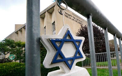 A Star of David hangs from a fence outside the dormant landmark Tree of Life synagogue in Pittsburgh's Squirrel Hill neighborhood on Tuesday, Oct. 26, 2021. (AP Photo/Gene J. Puskar, File)