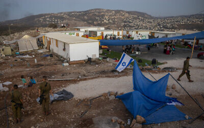 Israeli settlers and soldiers gather at the wildcat outpost of Evyatar near the West Bank city of Nablus, July 1, 2021. (Oded Balilty/AP)