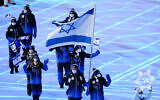 Evgeni Krasnopolski and Noa Szollos, of Israel, carry their national flag into the stadium during the opening ceremony of the 2022 Winter Olympics, Friday, Feb. 4, 2022, in Beijing. (AP Photo/Matt Slocum)