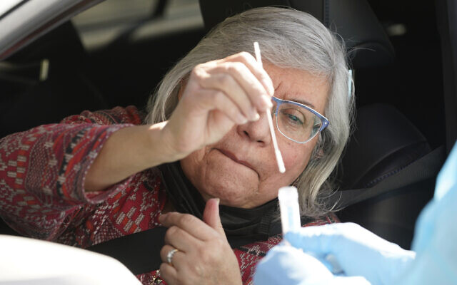 A woman self-tests for COVID-19 at a drive-thru testing site in Whittier, California, January 25, 2022. (AP Photo/Damian Dovarganes) A woman self-tests for COVID-19 at a drive-thru testing site in Whittier, California, January 25, 2022. (AP Photo/Damian Dovarganes)