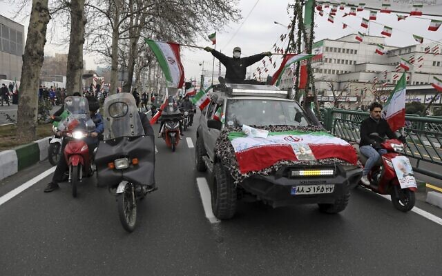 People parade with Iran's flags during the annual rally commemorating anniversary of1979 Islamic Revolution in Azadi (freedom) Sqaure in Tehran, Iran, Friday, Feb. 11, 2022 (AP Photo/Vahid Salemi)