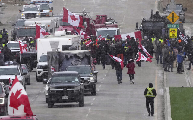 Protesters face police officers as they enforce an injunction against their demonstration, which has blocked traffic across the Ambassador Bridge by protesters against COVID-19 restrictions, in Windsor, Ont., Feb. 12, 2022. (Nathan Denette /The Canadian Press via AP)