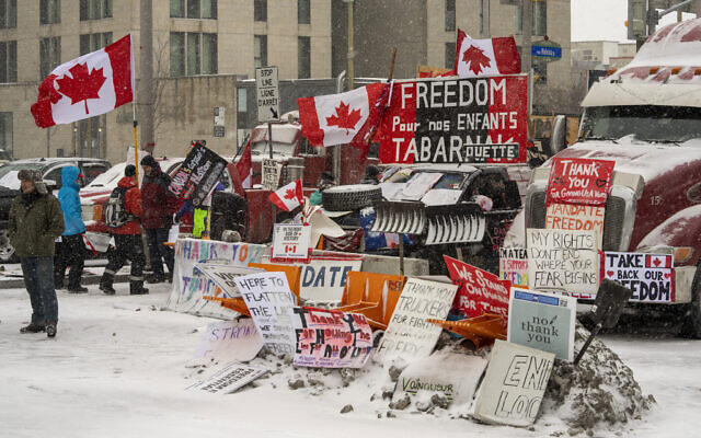 Anti-mandate protesters demonstrate in the snow during a demonstration against COVID-19 restrictions on Parliament Hill, in Ottawa, Feb. 12, 2022. (Frank Gunn /The Canadian Press via AP)